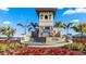 Beautiful community entrance with a stone tower, water feature, and lush landscaping at 18309 Canopy Pl, Lakewood Ranch, FL 34211