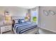 Nautical-themed bedroom featuring a striped blue bedspread, boat decorations, and a bright window view at 18313 Canopy Pl, Lakewood Ranch, FL 34211