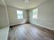 Cozy bedroom with wood-look floors, two windows, and an air conditioning unit for comfort at 1902 24Th W Ave, Bradenton, FL 34205