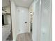 Hallway with wood-look floors, leading to a bathroom and bedrooms with closet storage at 1902 24Th W Ave, Bradenton, FL 34205