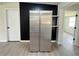 Clean and sleek stainless steel refrigerator, with modern black wood panel accent wall at 1902 24Th W Ave, Bradenton, FL 34205