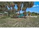 Secluded backyard with mature trees, a cozy seating area, and lush landscaping, perfect for relaxation at 2127 Corfell St, Port Charlotte, FL 33948