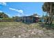 The home's exterior features a screened in patio and is surrounded by lawn at 2127 Corfell St, Port Charlotte, FL 33948