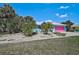 Charming home featuring lush landscaping, mature palms, and a colorful exterior, perfect for curb appeal at 2127 Corfell St, Port Charlotte, FL 33948
