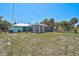 The home's exterior features a screened in patio, set on a spacious lot with lawn at 2127 Corfell St, Port Charlotte, FL 33948