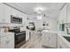 Open concept kitchen with stainless appliances flowing into the living and dining areas at 2127 Corfell St, Port Charlotte, FL 33948