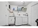 Functional laundry room with modern washer and dryer, storage, and utility sink at 2127 Corfell St, Port Charlotte, FL 33948