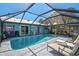 A delightful screened-in pool area with lounge chairs and an outdoor dining space for Gathering fun at 2127 Corfell St, Port Charlotte, FL 33948