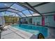 A refreshing screened-in pool, a pink door and a 'Beach' sign create a playful backyard oasis at 2127 Corfell St, Port Charlotte, FL 33948