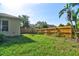 Green back yard with a wood fence, some foilage and a palm tree in a sunny day at 2809 112Th E Ter, Parrish, FL 34219