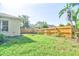 Green back yard with a wood fence, some foilage and a palm tree in a sunny day at 2809 112Th E Ter, Parrish, FL 34219