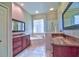 Well-lit bathroom featuring dual sinks, granite countertops, dark cabinets, and a tub at 2809 112Th E Ter, Parrish, FL 34219