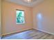 Bedroom with plank floors, light-pink walls, and a window overlooking lush greenery at 2809 112Th E Ter, Parrish, FL 34219