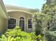Home's inviting front entrance features arched windows and decorative shrubbery, creating a welcoming curb appeal at 2809 112Th E Ter, Parrish, FL 34219