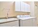 Convenient laundry room features a utility sink, washer, dryer, and cabinet storage at 2809 112Th E Ter, Parrish, FL 34219