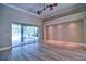 Open living room with wood floors and sliding glass doors to the pool area at 2809 112Th E Ter, Parrish, FL 34219