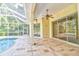 Covered patio area with ceiling fan adjacent to pool, creating a comfortable space for outdoor lounging at 2809 112Th E Ter, Parrish, FL 34219