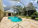 A screened-in pool area with a sparkling pool, attached spa and a lush green landscape provides a relaxing oasis at 2809 112Th E Ter, Parrish, FL 34219