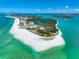 Aerial view showcasing a beautiful, pristine beach, luxurious hotels, and bright blue ocean waters at 290 N Washington Dr, Sarasota, FL 34236