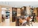 Stylish bar area with dark wood cabinets, seating, and a view into the game room at 290 N Washington Dr, Sarasota, FL 34236