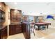 Elegant bar area with seating, dark wood cabinets, and a view into the game room at 290 N Washington Dr, Sarasota, FL 34236