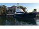 Waterfront home featuring a large boat docked in front with beautiful landscaping and trees at 290 N Washington Dr, Sarasota, FL 34236
