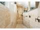 Walk-in shower with travertine tile, a built-in bench and multiple shower heads at 290 N Washington Dr, Sarasota, FL 34236