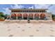 Building with a tiled roof, orange awnings, outdoor seating, and patterned concrete walkway at 3060 Grand Bay Blvd # 182, Longboat Key, FL 34228