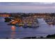 Marina with boats docked at dusk, city lights twinkling in the background at 3060 Grand Bay Blvd # 182, Longboat Key, FL 34228
