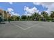 Outdoor tennis court surrounded by lush greenery and trees, with buildings in the background at 3060 Grand Bay Blvd # 182, Longboat Key, FL 34228