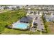 Aerial view of the pool and community center near single-Gathering homes, a parking lot, and lush green landscaping at 3108 Rock Sound St, Bradenton, FL 34208