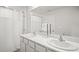 Bright bathroom features double sinks with marble countertop and shower with white curtain at 3108 Rock Sound St, Bradenton, FL 34208