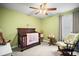 Charming Bedroom featuring a dark wood crib, rocking chair, and soft lighting, creating a cozy atmosphere at 3108 Rock Sound St, Bradenton, FL 34208