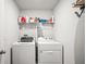 Functional laundry room with modern appliances and shelving for storage, providing convenience at 3108 Rock Sound St, Bradenton, FL 34208
