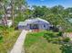 An aerial view of the house shows the driveway and lawn, plus mature landscaping and tree coverage at 3212 Avenue A W, Bradenton, FL 34205