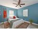 Bright bedroom with blue walls, wood-look floors, ceiling fan, and large windows at 3212 Avenue A W, Bradenton, FL 34205
