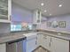 Bright kitchen featuring a farmhouse sink, granite countertops, and white cabinets at 3212 Avenue A W, Bradenton, FL 34205