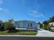 Charming single-story home featuring blue siding, a sliding glass door entry, and a well-kept lawn at 3212 Oakwood S Blvd, Sarasota, FL 34237