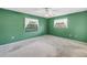 A bedroom with a green wall, fan and two windows at 3934 Brookside Dr, Sarasota, FL 34231