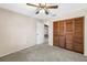 A beige walled bedroom with carpet, ceiling fan and a closet with wood paneled doors at 3934 Brookside Dr, Sarasota, FL 34231
