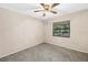A beige walled bedroom with carpet and a ceiling fan and view to the yard at 3934 Brookside Dr, Sarasota, FL 34231