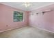 Bright bedroom featuring neutral carpet, a ceiling fan, and a window with tree views at 3934 Brookside Dr, Sarasota, FL 34231
