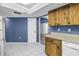 View of kitchen with blue walls, tile floors, wood cabinets and white appliances at 3934 Brookside Dr, Sarasota, FL 34231