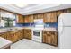 Eat-in kitchen with wood cabinets and white appliances at 3934 Brookside Dr, Sarasota, FL 34231