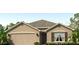 Charming one-story home with a two-car garage, neutral stucco exterior, and well-manicured landscaping at 4423 Dusky Dawn Ln, Palmetto, FL 34221