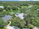 Stunning aerial view of home with solar panels surrounded by mature trees and overlooking a lake at 4443 Robin Hood W Trl, Sarasota, FL 34232