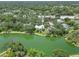 Expansive aerial view of home near a lake, offering a glimpse of the lush tree cover and neighborhood at 4443 Robin Hood W Trl, Sarasota, FL 34232