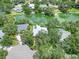 Beautiful aerial of home with solar panels, lush foliage and lake creating privacy and natural beauty at 4443 Robin Hood W Trl, Sarasota, FL 34232