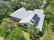Aerial view featuring a home with solar panels, screened-in porch, and well-manicured landscaping at 4443 Robin Hood W Trl, Sarasota, FL 34232