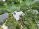 Aerial view of home with solar panels and lush greenery, nestled on a waterfront lot at 4443 Robin Hood W Trl, Sarasota, FL 34232